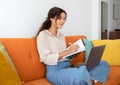 Beautiful Young Woman Taking Notes To Notepad While Using Laptop At Home Royalty Free Stock Photo