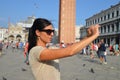 A beautiful young woman taking a photos with her smartphone in Venice Royalty Free Stock Photo