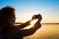 Beautiful young woman taking picture of herself, selfie, on a beach Royalty Free Stock Photo