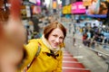 Beautiful young woman taking a selfie with her smartphone on Times Square Royalty Free Stock Photo