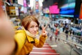 Beautiful young woman taking a selfie with her smartphone on Times Square Royalty Free Stock Photo