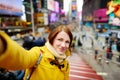 Beautiful young woman taking a selfie with her smartphone on Times Square Royalty Free Stock Photo