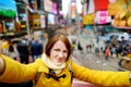 Beautiful young woman taking a selfie with her smartphone on Times Square Royalty Free Stock Photo