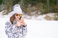 Beautiful young woman taking a selfie in winter nature. Pretty woman taking a photo in a nature. Winter background.
