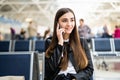 Beautiful young woman talking on cell phone at airport Royalty Free Stock Photo