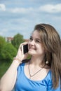 Beautiful young woman talking on the cell-phone outdoor. Royalty Free Stock Photo