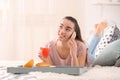 Beautiful young woman talking by mobile phone while drinking citrus juice and having breakfast at home Royalty Free Stock Photo