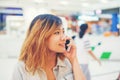 Beautiful young woman talking on the phone in the shopping mall. Royalty Free Stock Photo
