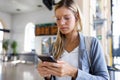 Beautiful young woman texting with her mobile phone in the train station hall. Royalty Free Stock Photo