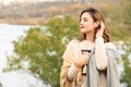 Beautiful young woman with thermos resting outdoors