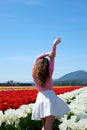 beautiful young woman tiptoeing through tulips across field ad purity freshness white skirt pink blouse snow-white