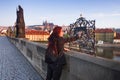 Beautiful young woman is touching the bronze plaque on Charles bridge for good luck. Prague. Royalty Free Stock Photo