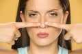 Beautiful young woman touching her nose with her fingers Royalty Free Stock Photo