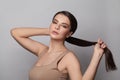 Beautiful young woman touching her ponytail hairstyle with smooth straight hair