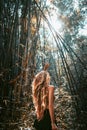 Beautiful young woman tourist in hat at bamboo forest