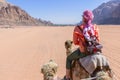 Beautiful young woman tourist in white dress riding on camel in wadi rum desert, Jordan Royalty Free Stock Photo