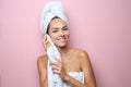 Beautiful young woman with towel wiping skin after shower on color background