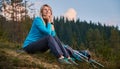 Beautiful young woman traveler sitting on grassy hill. Royalty Free Stock Photo