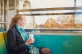 Beautiful young woman travelling in a train of Parisian underground and drinking coffee Royalty Free Stock Photo