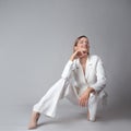 Beautiful young woman in a trendy white suit, jacket and trousers, Royalty Free Stock Photo