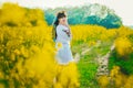 Beautiful young woman in Ukrainian embroidered standing in a field of yellow flowers Royalty Free Stock Photo