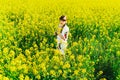 Beautiful young woman in Ukrainian embroidered standing in a field of yellow flowers Royalty Free Stock Photo