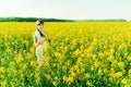 Beautiful young woman in Ukrainian embroidered standing in a field of yellow flowers Royalty Free Stock Photo