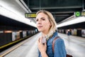 Beautiful young woman at the underground platform, waiting