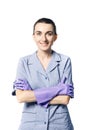 A beautiful young woman in the uniform of a maid smiling crossed her hands in rubber gloves on her chest. Royalty Free Stock Photo