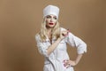 A beautiful young woman in the uniform of a nurse with a syringe in her hand. Sexy blonde with red lips. Compulsory vaccination Royalty Free Stock Photo