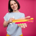 Beautiful young woman uses an oral care kit consisting of a tongue scraper, single tufted and interdental brush