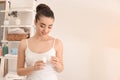 Beautiful young woman using deodorant in morning Royalty Free Stock Photo