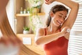 Happy young woman using roll on deodorant Royalty Free Stock Photo