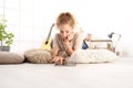 Beautiful young woman using a digital tablet with earphones, lying on living room wooden floor Royalty Free Stock Photo