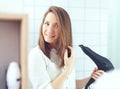 Beautiful young woman  using hair dryer drying hair. Hair care Royalty Free Stock Photo