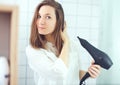 Beautiful young woman  using hair dryer drying hair. Hair care Royalty Free Stock Photo