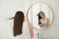 Beautiful young woman using hairdryer in bathroom Royalty Free Stock Photo