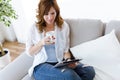 Beautiful young woman using her digital tablet at home. Royalty Free Stock Photo