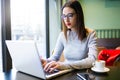 Beautiful young woman using her laptop in the coffee shop. Royalty Free Stock Photo