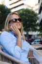 Beautiful young woman using her mobile phone in a restaurant terrace. Royalty Free Stock Photo