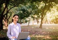 Beautiful young woman using laptop computer at public park in the morning,Happy and smiling,Relaxing time Royalty Free Stock Photo