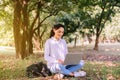 Beautiful young woman using laptop computer at public park in the morning,Happy and smiling,Relaxing time,Positive thinking Royalty Free Stock Photo