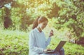 Beautiful young woman using laptop computer at public park in the morning,Happy and smiling,Relaxing time,Positive thinking Royalty Free Stock Photo