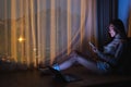 A beautiful young woman using mobile phone and laptop computer with bright light screen in the late night at home Royalty Free Stock Photo