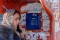 Beautiful young woman using a public payphone Royalty Free Stock Photo