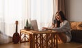 A beautiful young woman using and working on laptop computer while drinking coffee at home Royalty Free Stock Photo