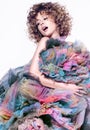 A beautiful young woman and a variety of colorful fabrics. Cute curly hair