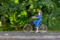 Beautiful young woman and vintage bicycle, summer. Red hair girl riding the old black retro bike outside in the park. Royalty Free Stock Photo