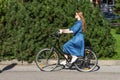 Beautiful young woman and vintage bicycle, summer. Red hair girl riding the old black retro bike outside in the park Royalty Free Stock Photo