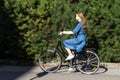 Beautiful young woman and vintage bicycle, summer. Red hair girl riding the old black retro bike outside in the park. Royalty Free Stock Photo